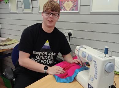 Peter sitting by a sewing maching