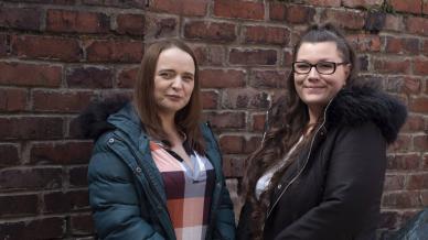 Emma and Sarah stood next to a wall