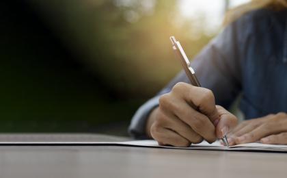 Image showing someone writing into a notepad