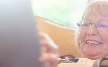 A photograph of a woman using a tablet device.