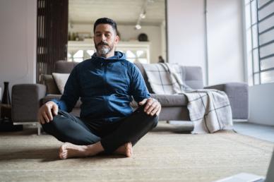 Man meditating in living room
