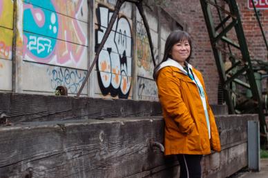 Lady standing next to a graffiti wall