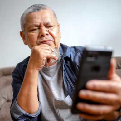 Older gentleman looking at a mobile phone screen