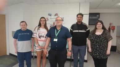 Tutor and four students pose for image in community venue