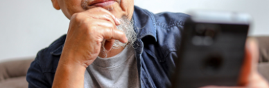 Older gentleman looking at a mobile phone screen